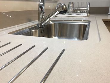 Pia de cozinha com descanso de panela e varetas de inox polido, torneira e cuba inox.