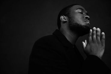Black and white portrait of a man praying devoutly