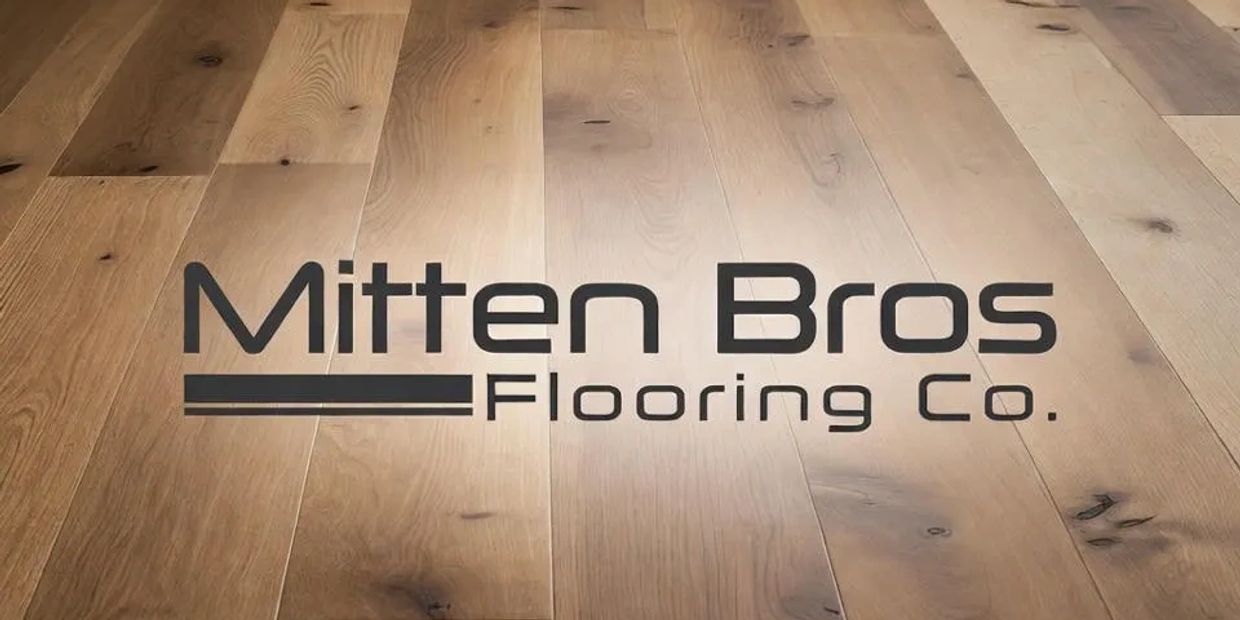 Logo of Mitten Bros Flooring Co. on wooden floor.