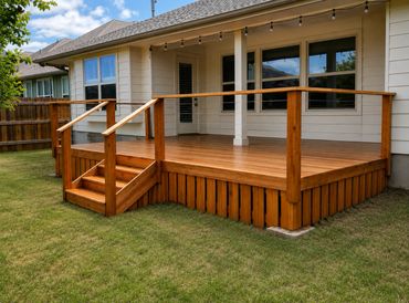 A wooden deck with stairs attached to a house backyard.