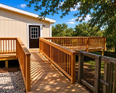 Wooden ramp and deck leading to a beige house door under a sunny sky.
