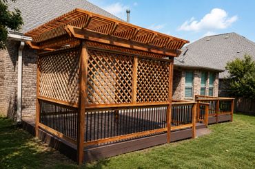 Wooden pergola with lattice panels on a backyard deck beside a brick house.