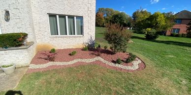 Freshly installed red rock with small strip of white rock around it in holmdel nj