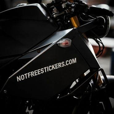 Close-up of a black motorcycle with NOTFREESTICKERS.COM decal.
