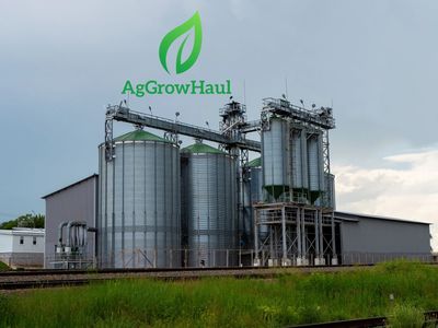 Industrial grain storage facility with AgGrowHaul logo.