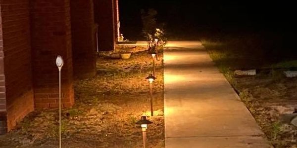 Sidewalk with walkway lights, ground lights.
