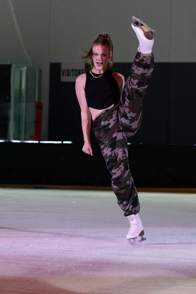 Figure skater kicking leg above her head