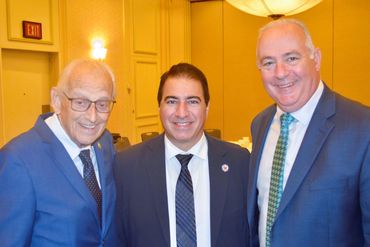 Two women and one man in business attire networking at a corporate conference