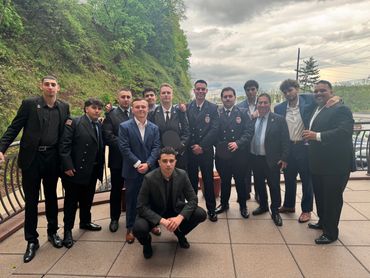 Group of professionals in suits shaking hands at a formal business event