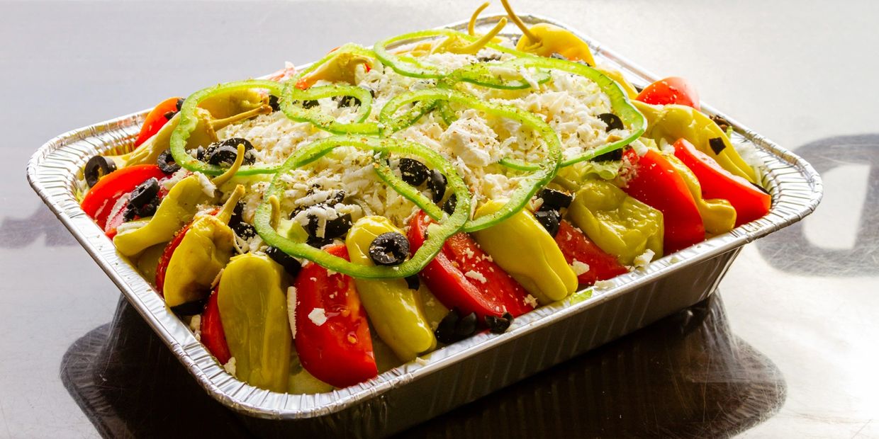 A container with peppers and chilies and cheese 