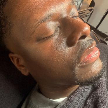 Close-up of a man resting with eyes closed, bathed in warm light.