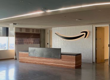 Modern office reception with Amazon logo on the wall.