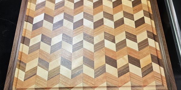 Intricately patterned wooden cutting board with chevron design.