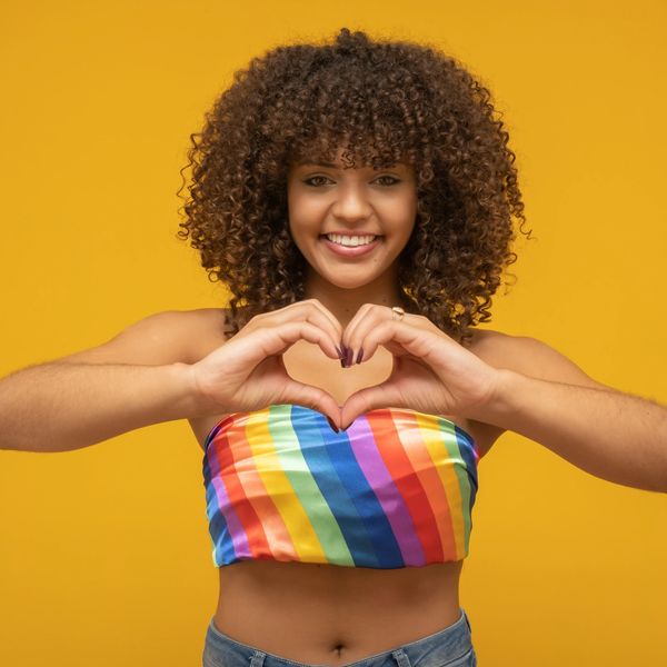 Female with shoulder length curly haircut type 3 with brown hair color on a yellow background