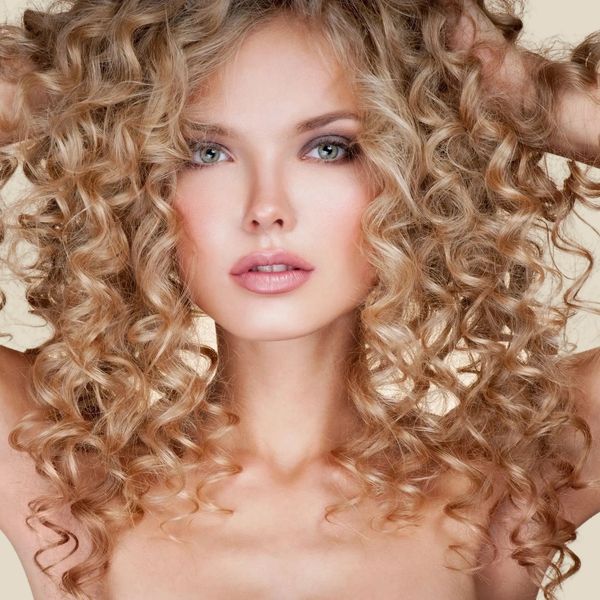 A proud female with blonde hair underwent a life-changing transformation with a curly haircut.