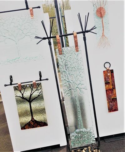 glass artwork hanging from copper pins