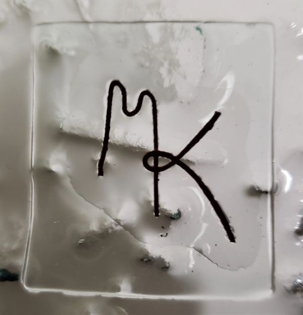 glass artwork with black MK string