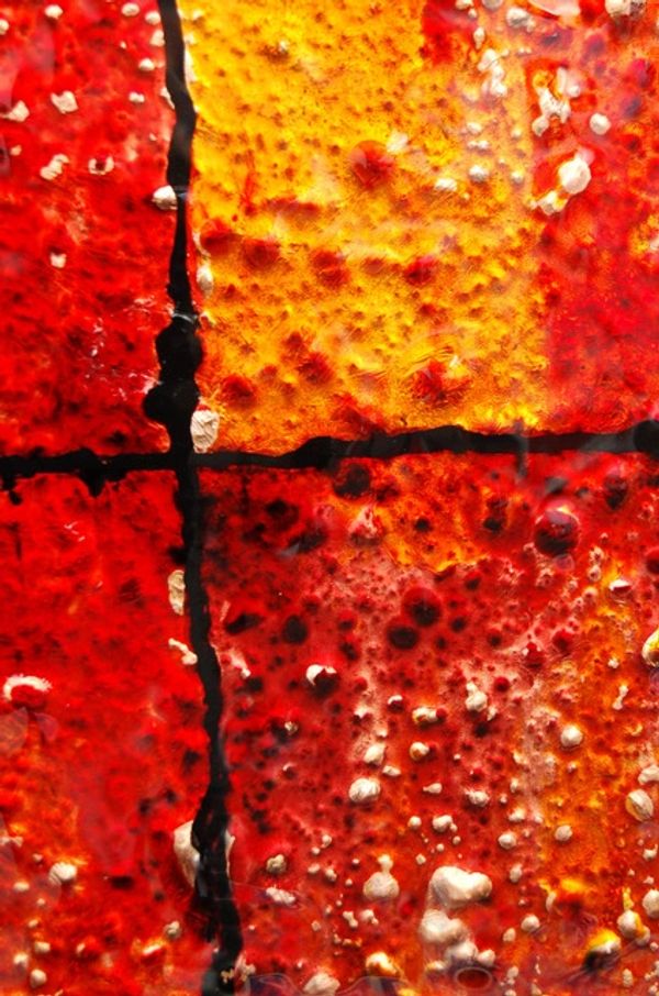 closeup of glass artwork in reds and yellows
