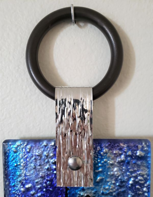 closeup of glass artwork hanging on black round hook