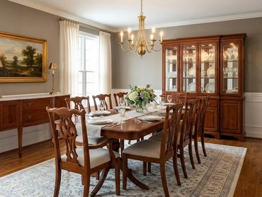 Elegant dining room with wooden furniture, chandelier, and classic decor.