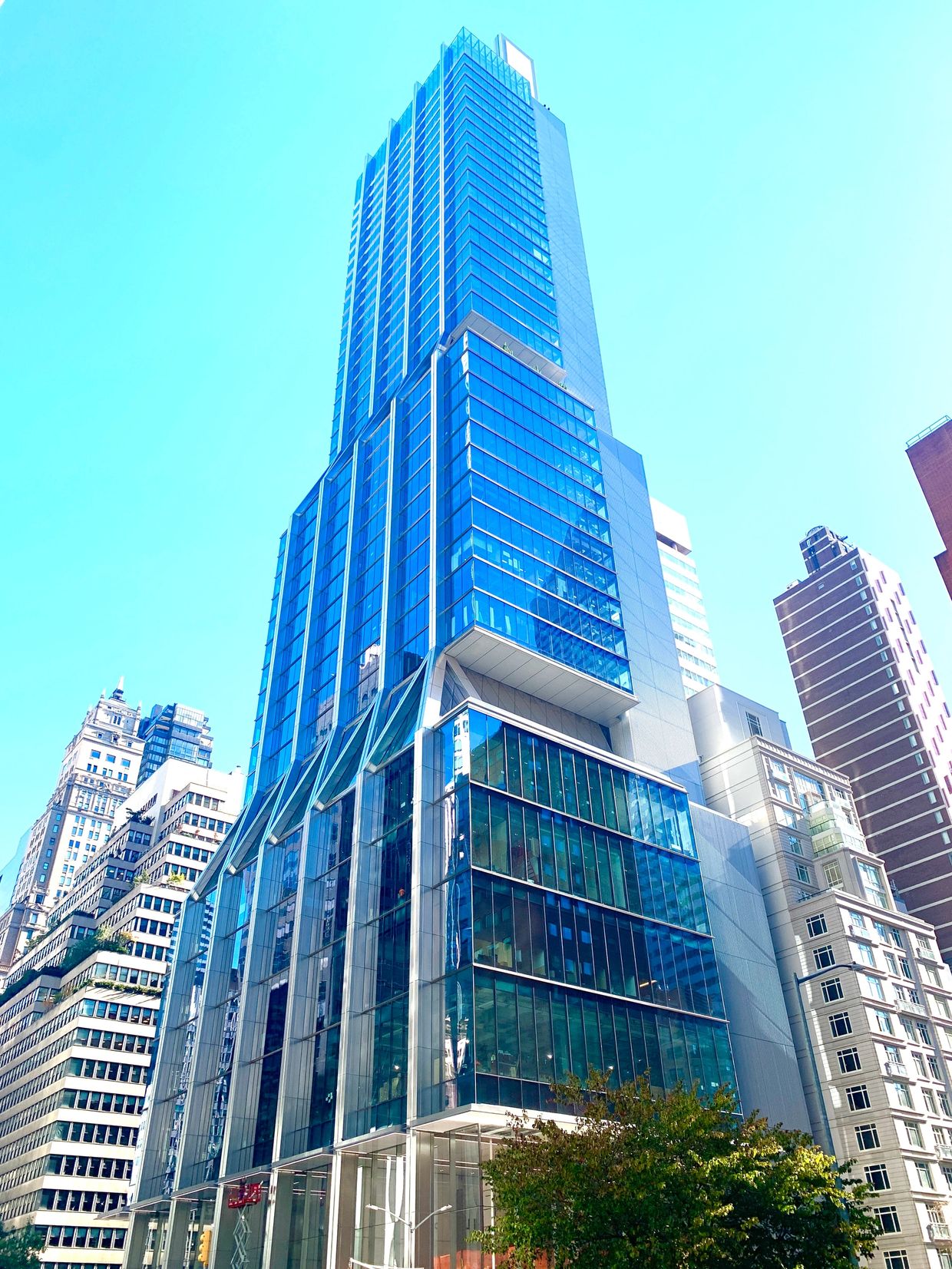 Modern glass skyscraper towering against a clear blue sky.