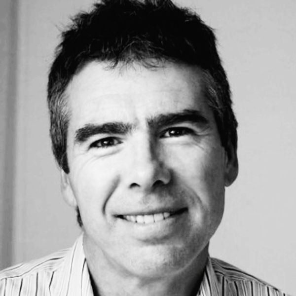 Black and white portrait of a smiling middle-aged man.