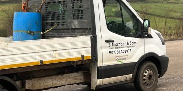 Work truck of B Thornber & Sons with tools and equipment in the back.