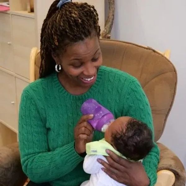 Woman feeding a baby with a bottle.