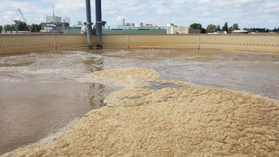 Large open tank filled with frothy liquid, likely in an industrial setting.