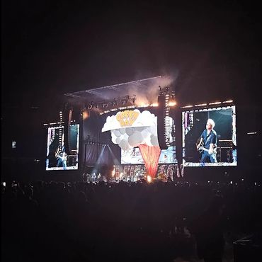 Green Day performing live on a large stage with bright lights and big screens.