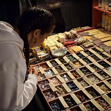Person examining a display of various stones and spiritual items.
