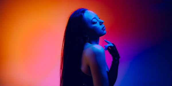 Woman lit in blue and orange light.