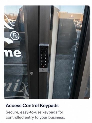 Electronic access control keypad on a glass door for secure business entry.