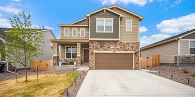Modern two-story house with stone and siding exterior and a spacious driveway.