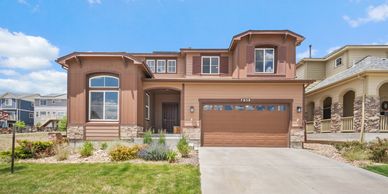 Modern two-story house with a brown exterior and attached garage.
