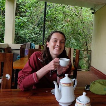 Person enjoying tea at a wooden table.