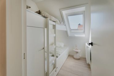 Compact bedroom with bunk beds and a skylight window.
