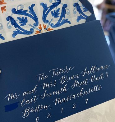 Whispy, flowy script in white ink on navy envelopes with decorative liner.