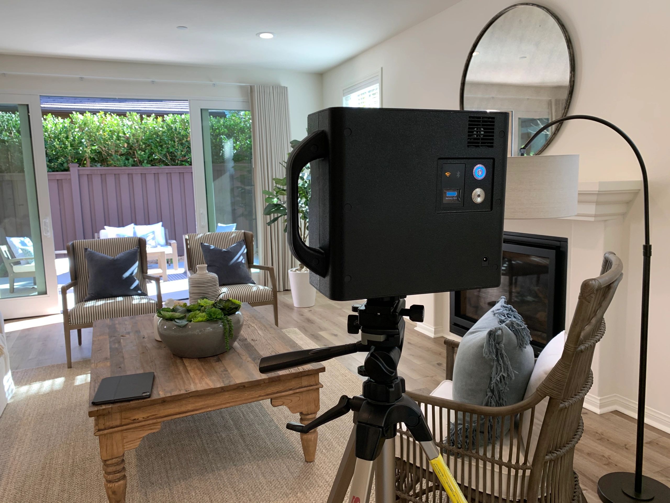 The Matterport camera on a tripod in a living room of a house.