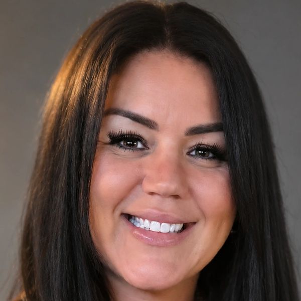 Close-up portrait of a smiling woman with long dark hair.