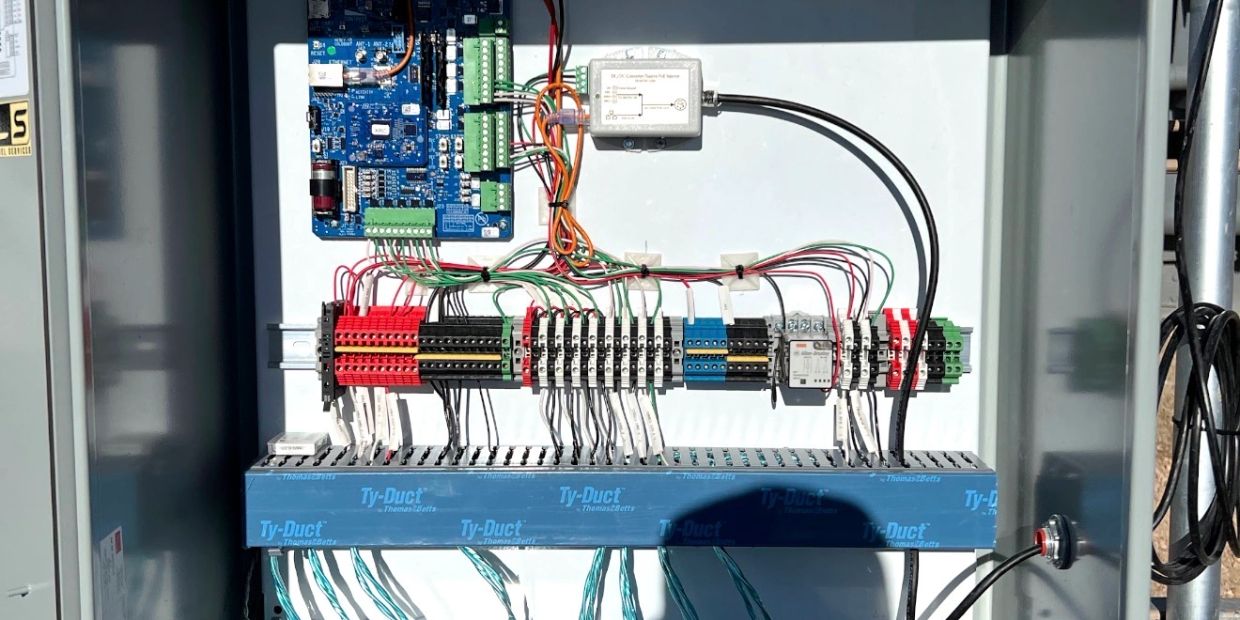 Organized electrical panel with circuit boards and neatly arranged wires.