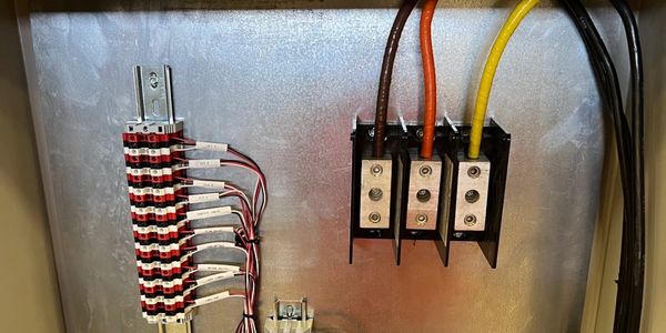 Electrical panel with organized wiring and labeled terminals.