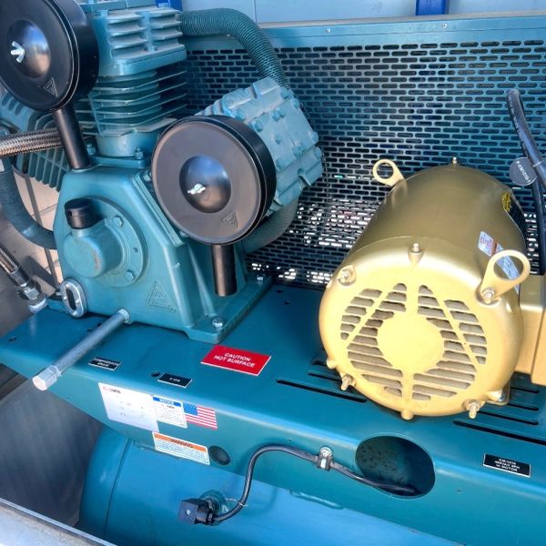 Industrial machinery with warning labels and ventilation.