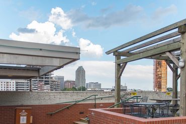Outdoor seating area with wooden pergola and beer list chalkboard.