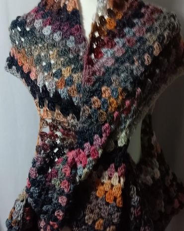 Colorful crocheted shawl with intricate patterns and warm tones.