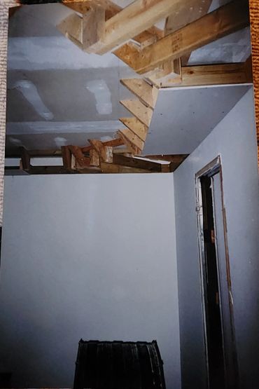 Unfinished wooden staircase inside a room under construction.