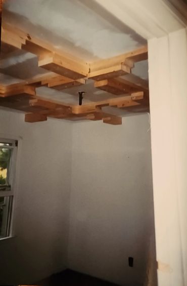 Wooden ceiling installation in progress inside a room.