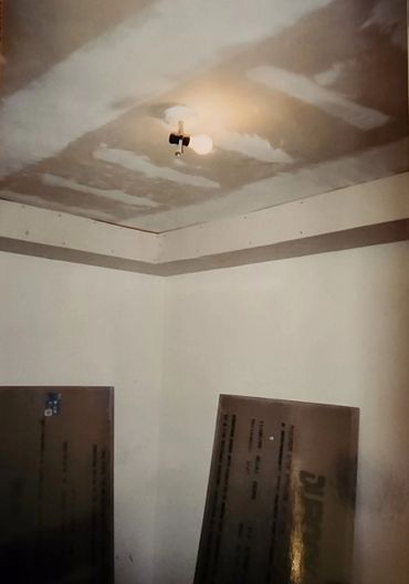 Room under construction with a light bulb on the ceiling.