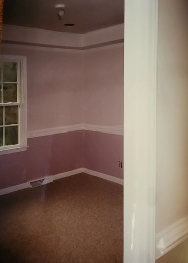 Empty room with pink walls and a window.