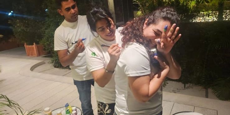 Three friends having fun drawing on each other's backs.